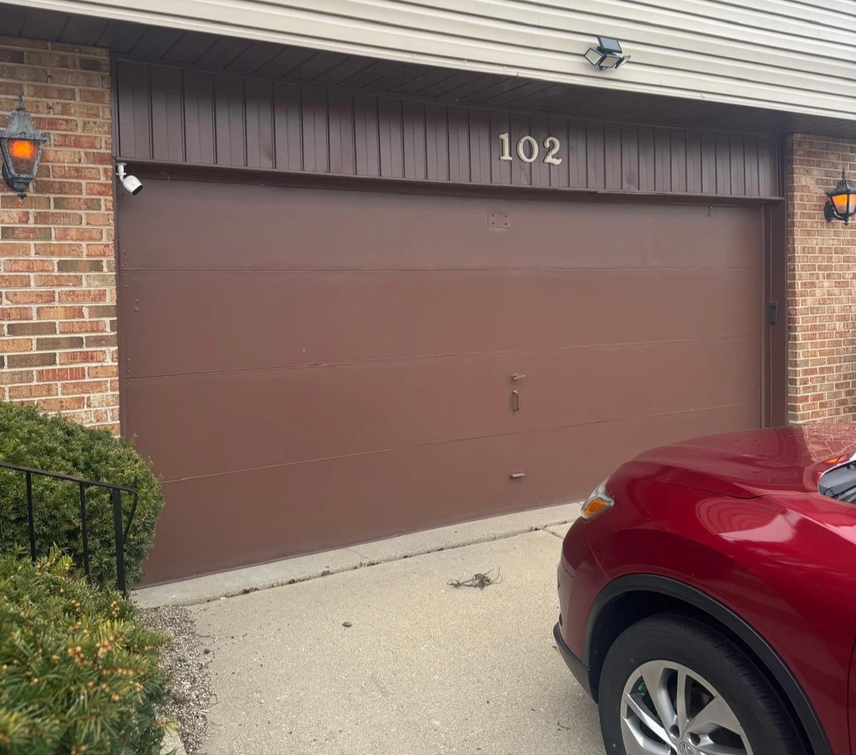 Before Garage Door Replacement Project Before image of an older residential garage door prior to replacement